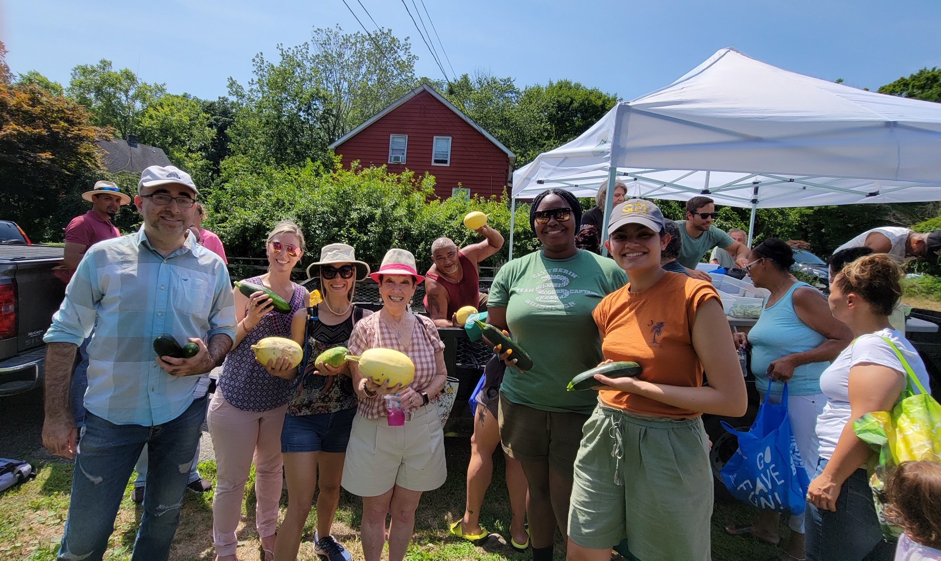 Members of the Ramapough tribe and volunteers from NYU hold vegetables at a free farmers market for the community.