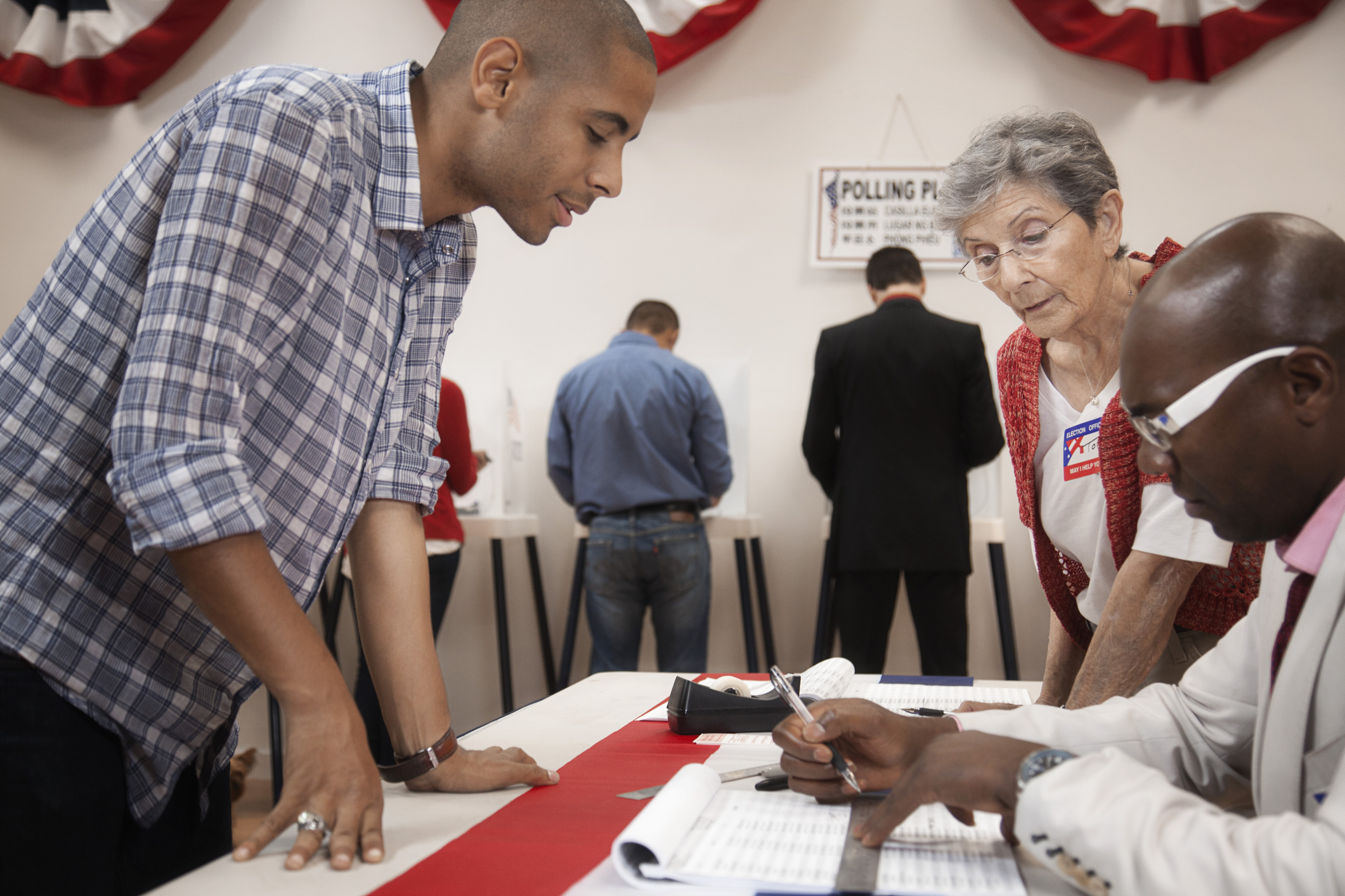 Man arriving at registration desk in polling place