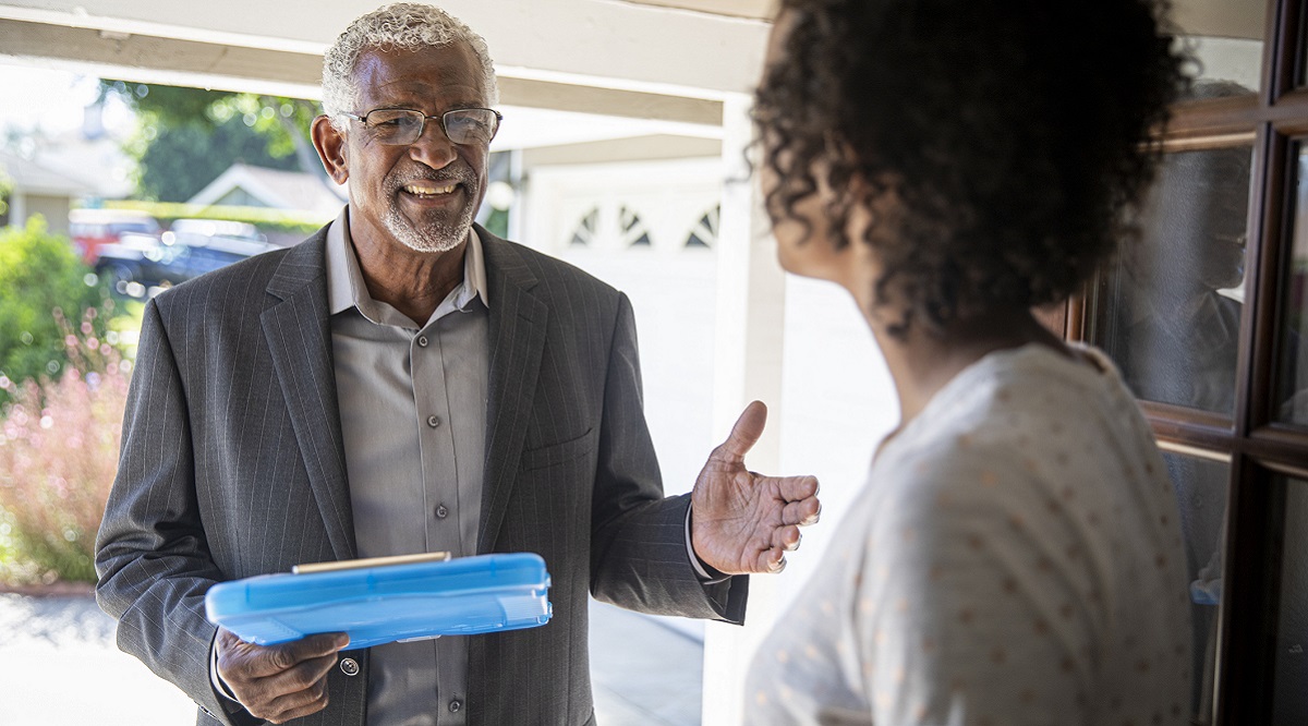 A senior black man visits with a potential voter to earn her support.
