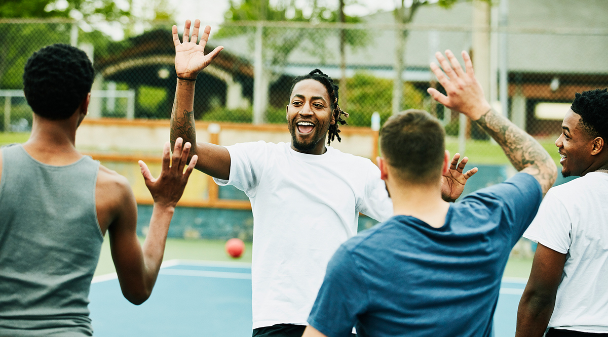 Smiling person high fiving teammates after winning dodgeball game