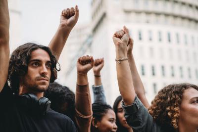 Young people raising their fists in solidarity at a protest.