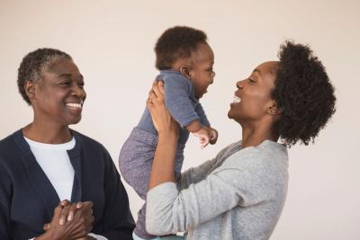 Maternal Health Incubator Family Young parent holds their baby with happy grandparent