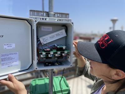 A person checks a community air monitoring station in San Ysidro.