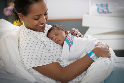 Maternal Health Incubator Save the Date Image of a person holding a newborn baby in a hospital bed