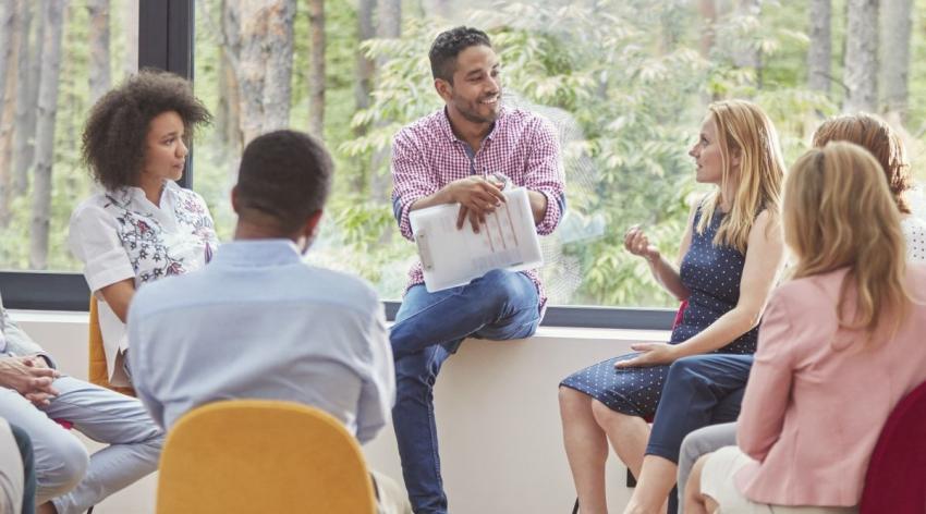 A group of people sits together discussing a topic.