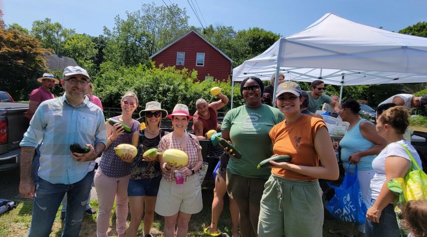 Members of the Ramapough tribe and volunteers from NYU hold vegetables at a free farmers market for the community.