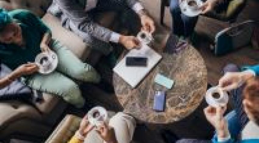 A group of colleagues shares coffee and conversation