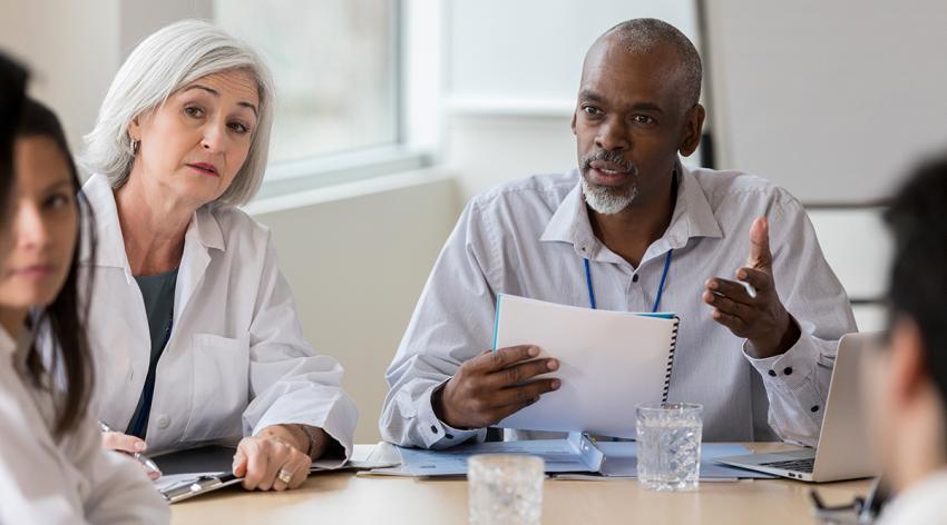 Senior businessman speaks seriously with medical staff
