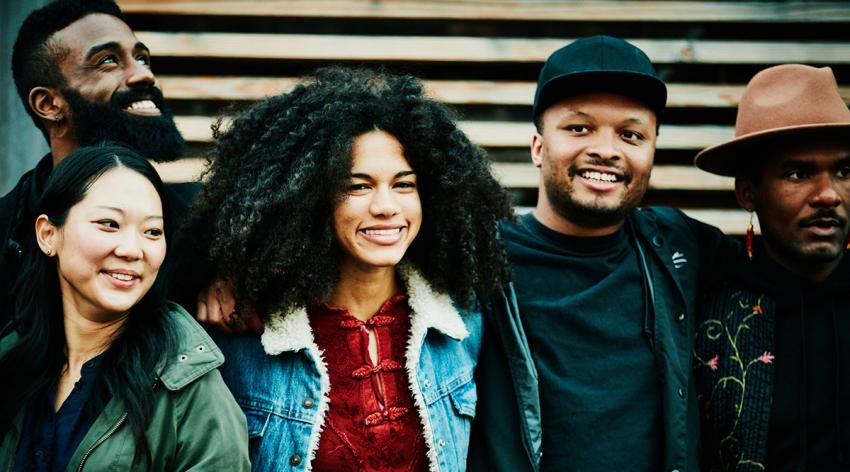 Smiling friends posing for a photo while standing outside